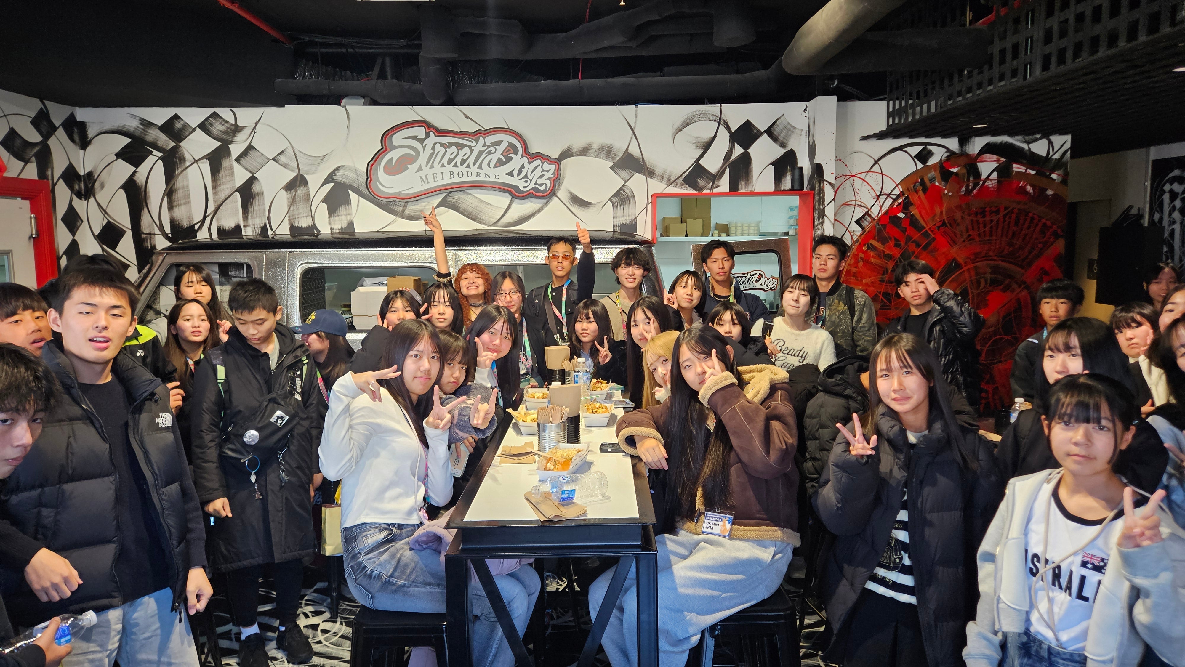 Group of people posing together in a room with graffiti art on the walls.