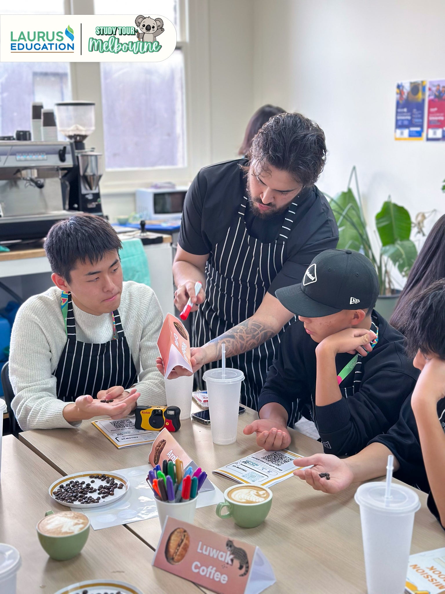 Group of people in a coffee shop setting with Laurus Education branding.